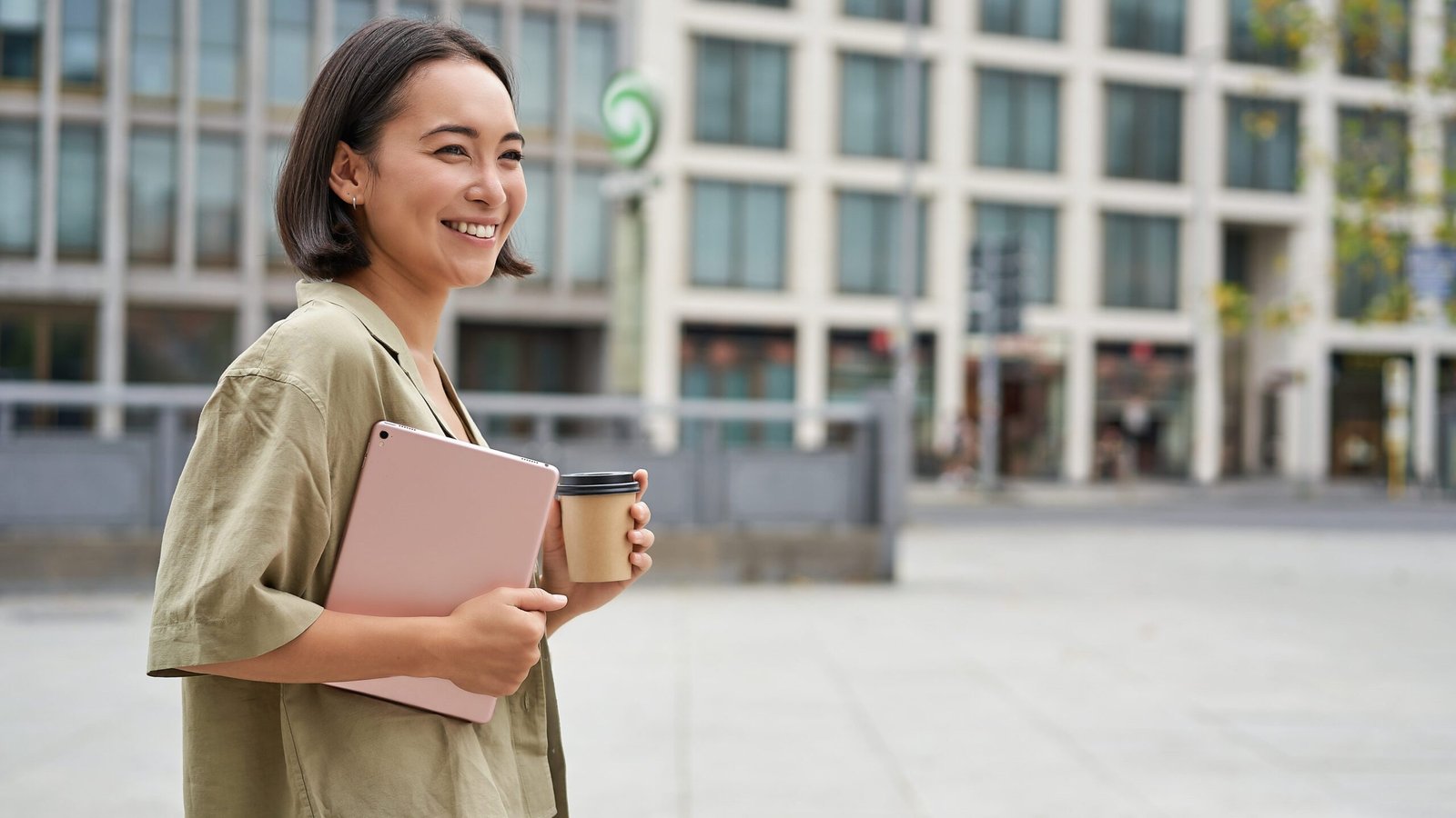 Stylish city girl with tablet, walking on street and drinking takeaway coffee, going to university or work.
