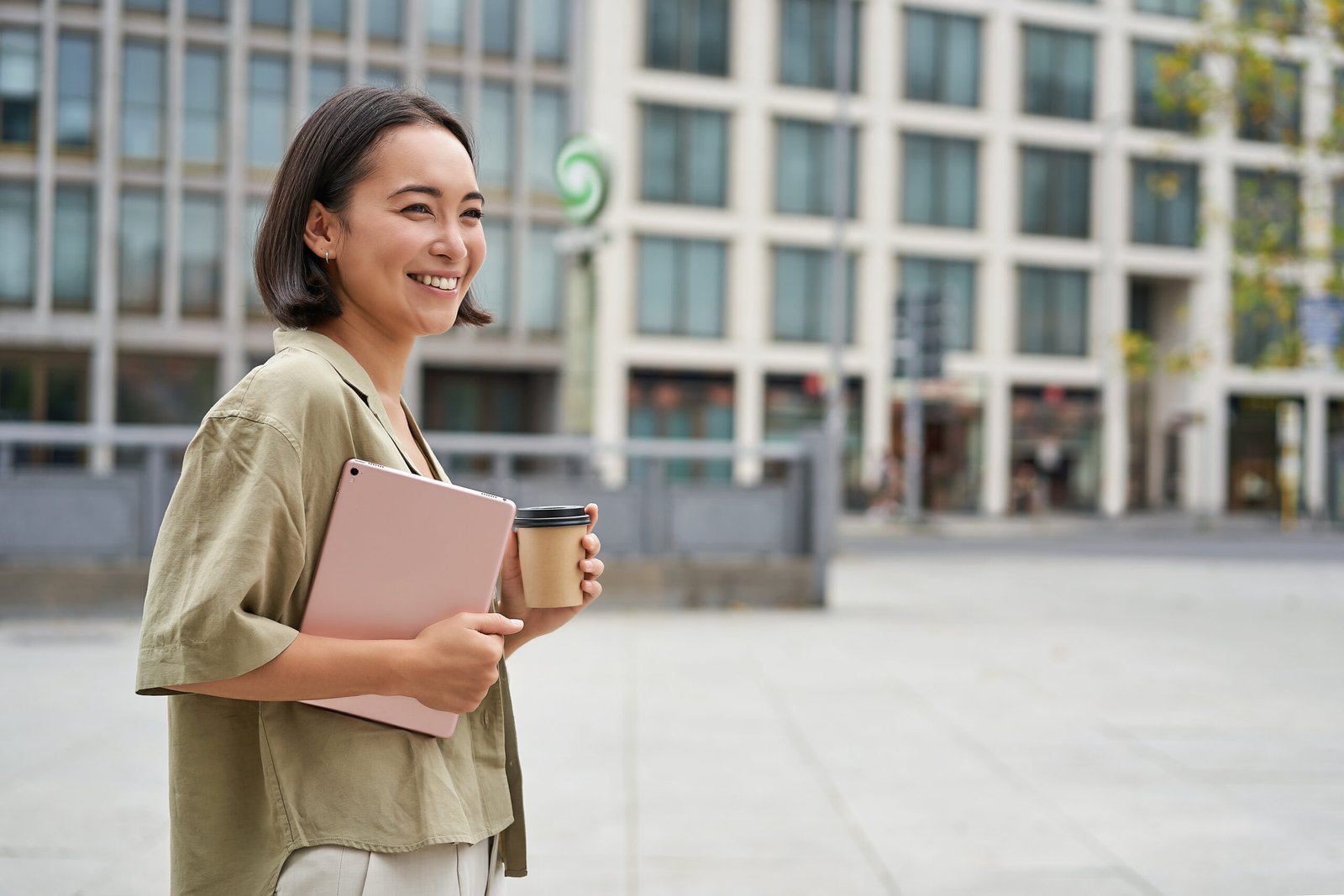 Stylish city girl with tablet, walking on street and drinking takeaway coffee, going to university or work.